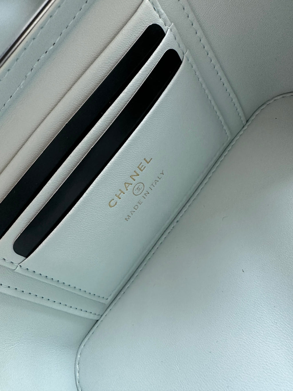 Light-blue card holder compartment with Chanel text and embossed slot design