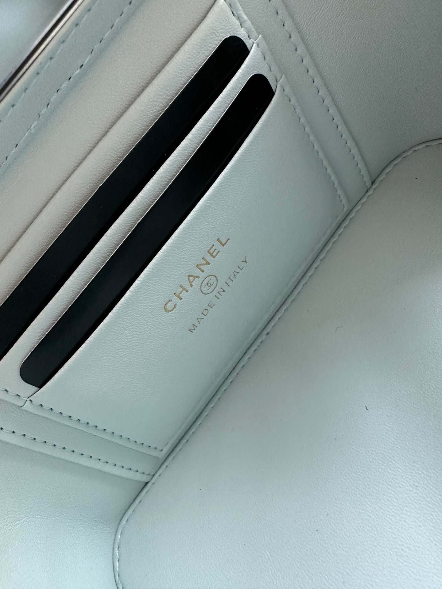 Light-blue card holder compartment with Chanel text and embossed slot design