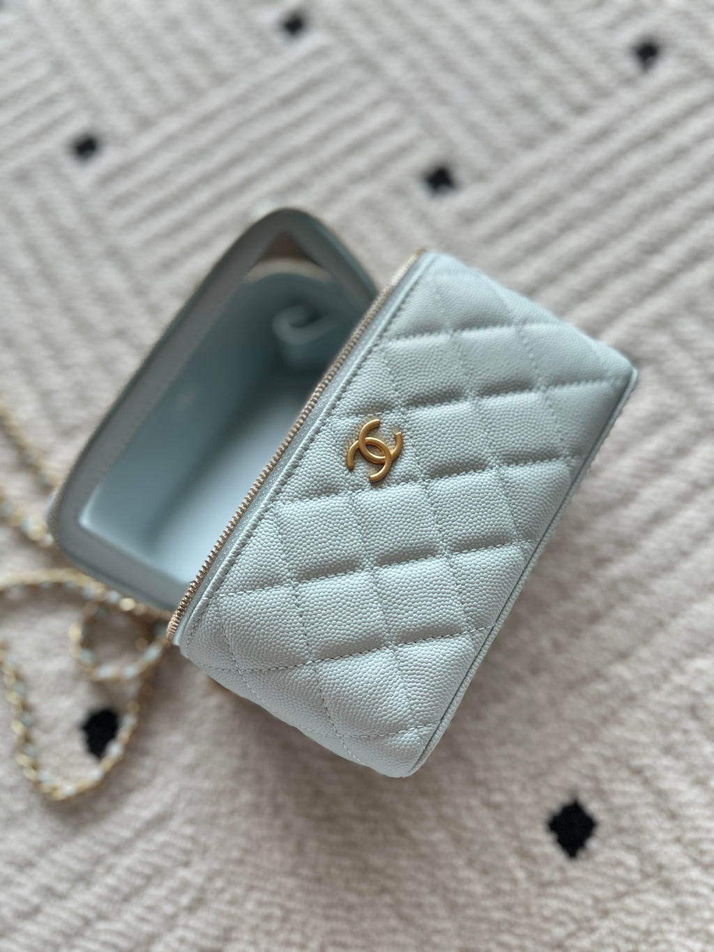 Light-blue mini quilted wallet bag with gold zipper and Chanel logo charm