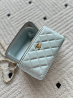 Light-blue mini quilted wallet bag with gold zipper and Chanel logo charm