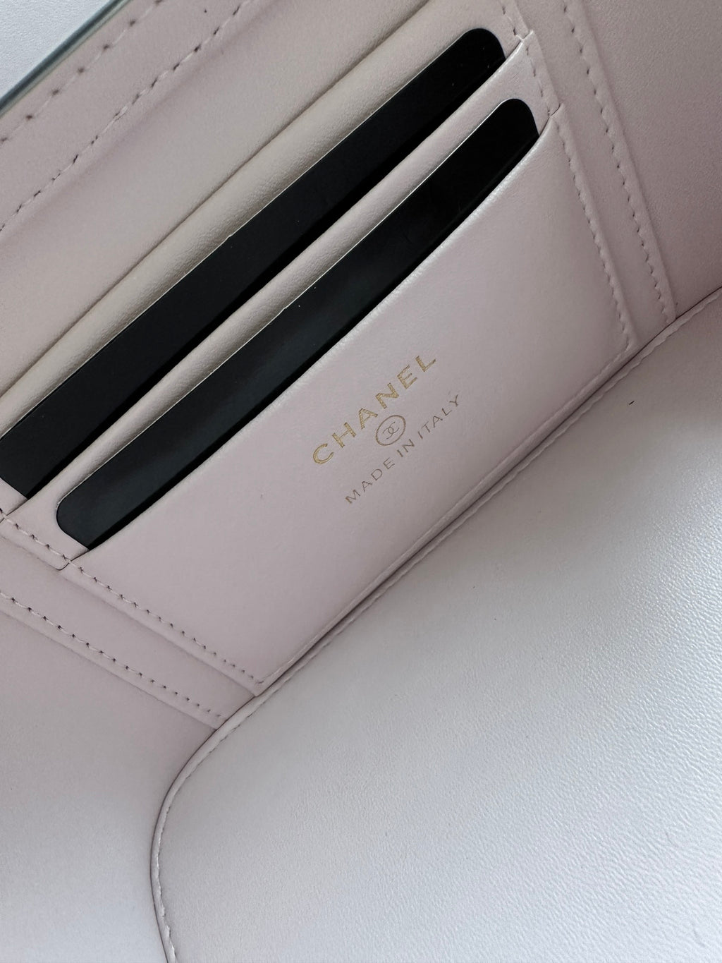 Chanel card holder inside mini bag in pink showing CHANEL logo and card slot