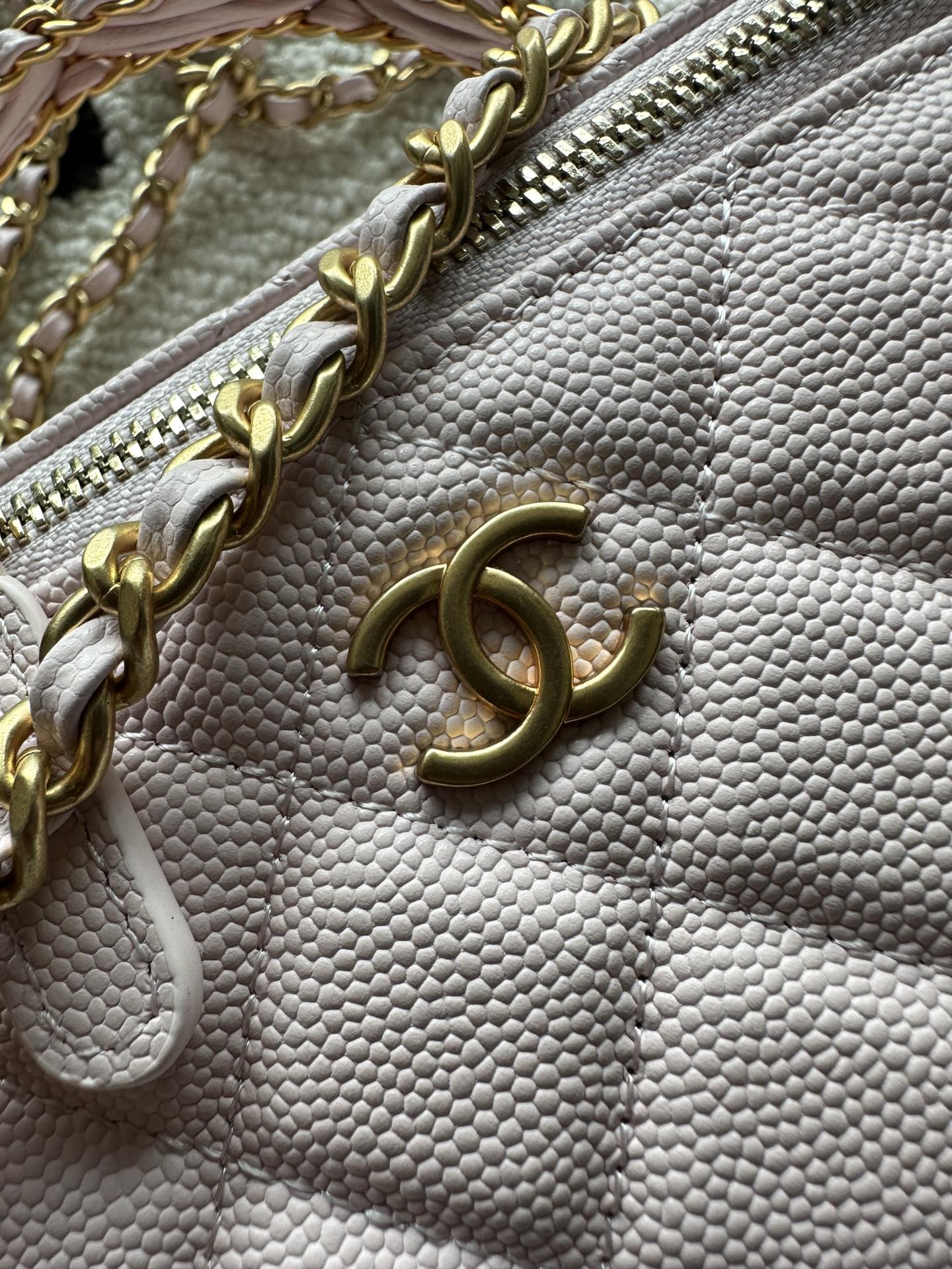 Chanel mini bag in pink with gold chain, zipper detail, and logo charm