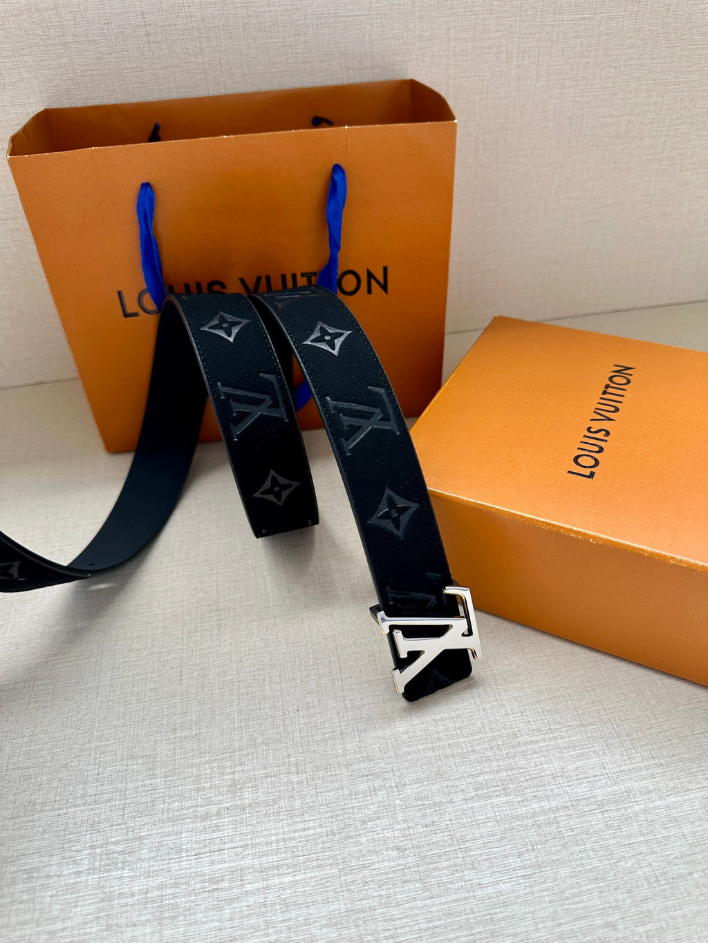 Louis Vuitton navy monogram belt with gold-tone buckle, belt ends spread out