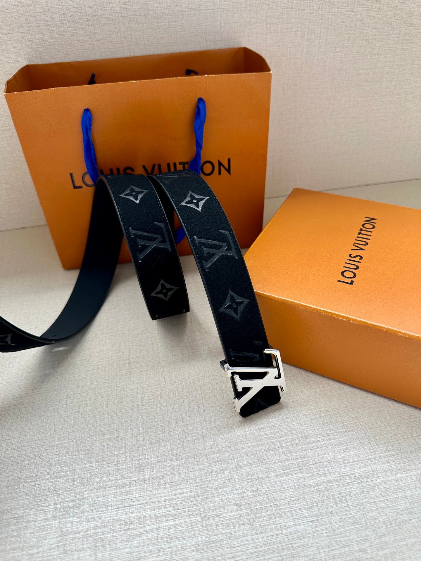 Louis Vuitton navy monogram belt with gold-tone buckle, belt ends spread out