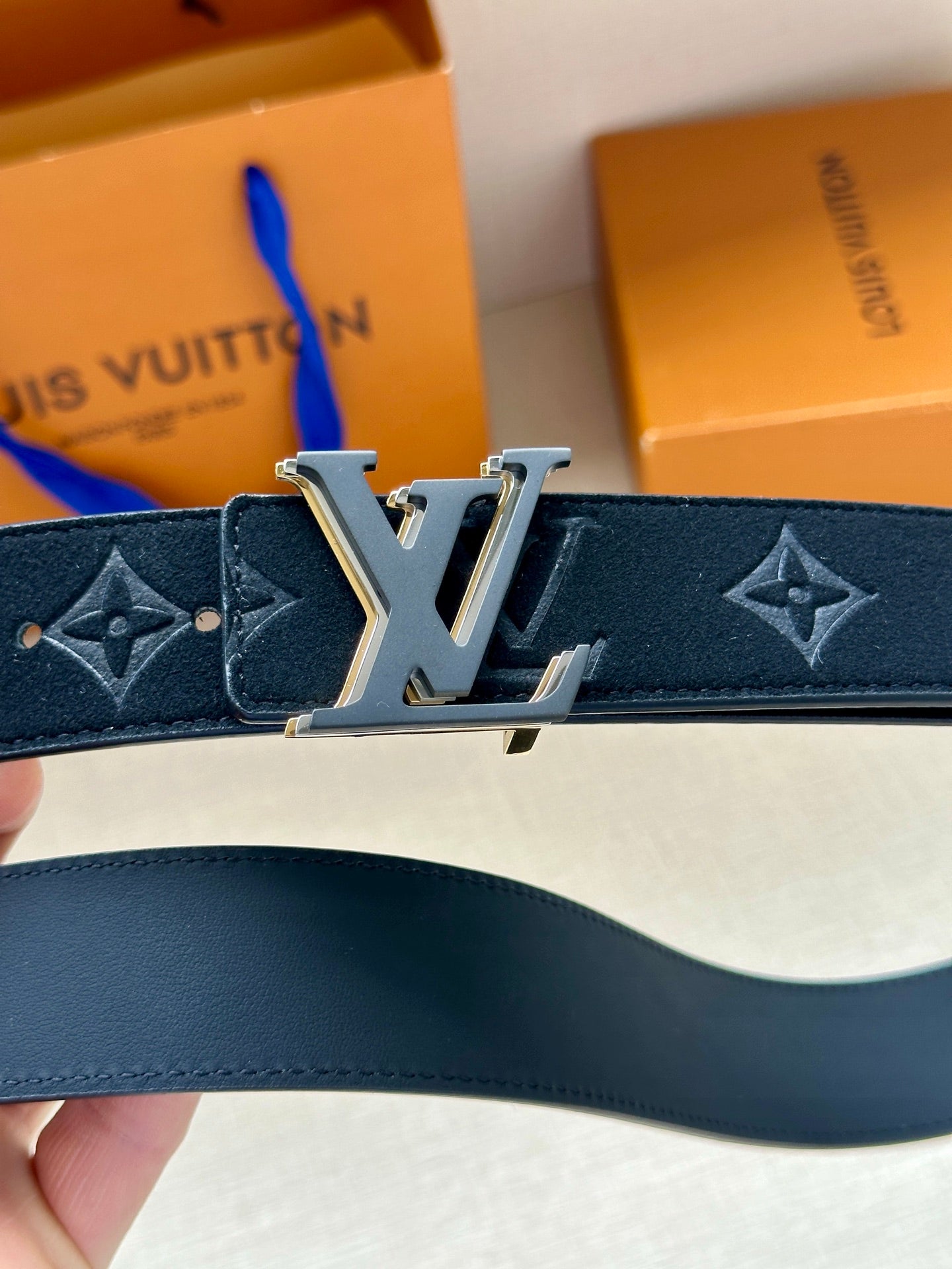Louis Vuitton navy monogram belt, close-up of gold-tone prong buckle