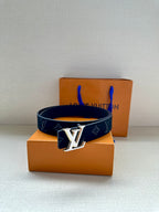 Louis Vuitton navy monogram belt with gold-tone LV buckle on top of box