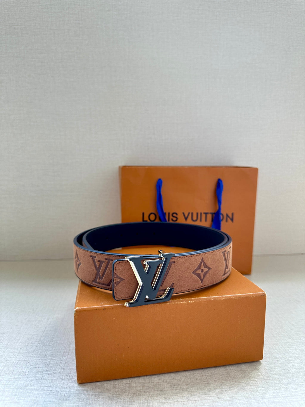Louis Vuitton belt with brown monogram strap and gold-tone LV buckle, dark interior