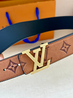 Louis Vuitton belt close-up: tan monogram strap with gold-tone LV buckle