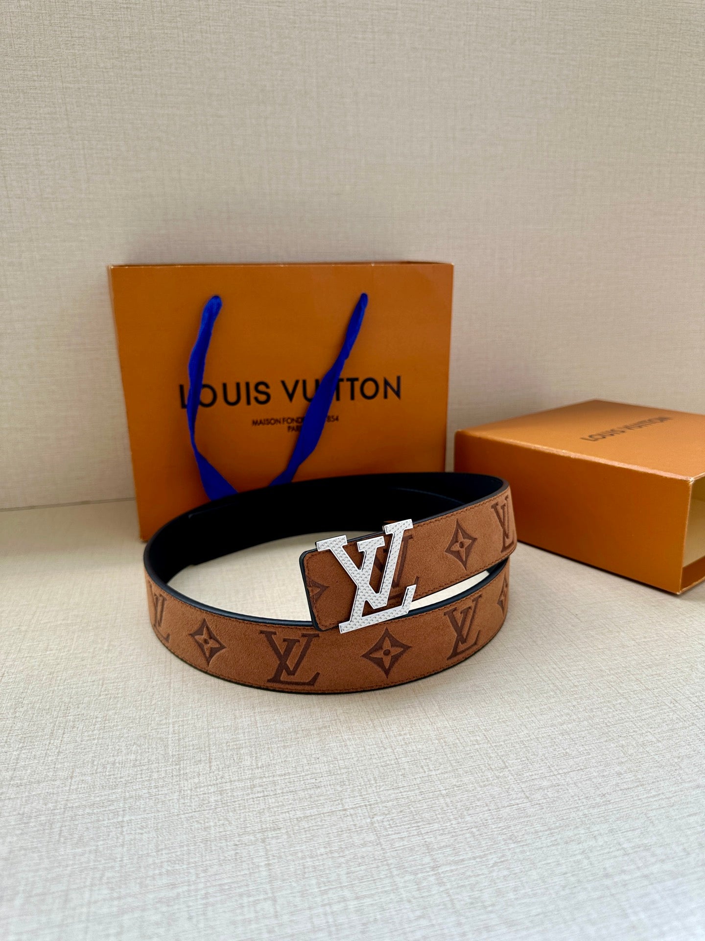 Louis Vuitton monogram belt, tan strap with gold-tone buckle and dark strap underside