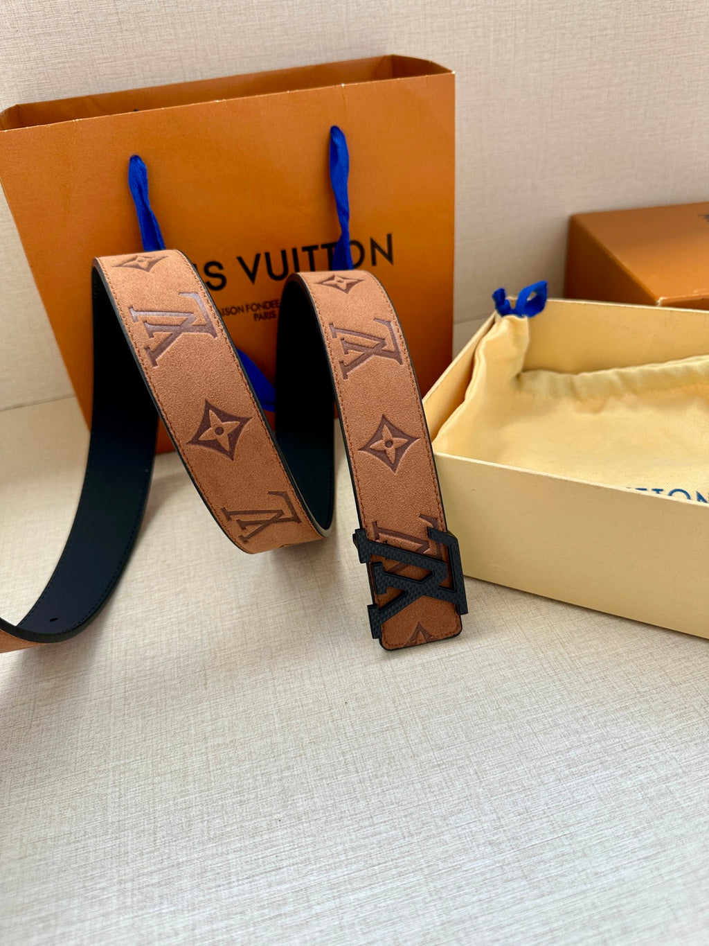 Louis Vuitton monogram belt with tan strap and gold-tone buckle, stacked belt detail