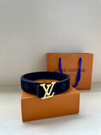 Dark blue patterned belt with silver LV logo buckle; belt looped and centered.