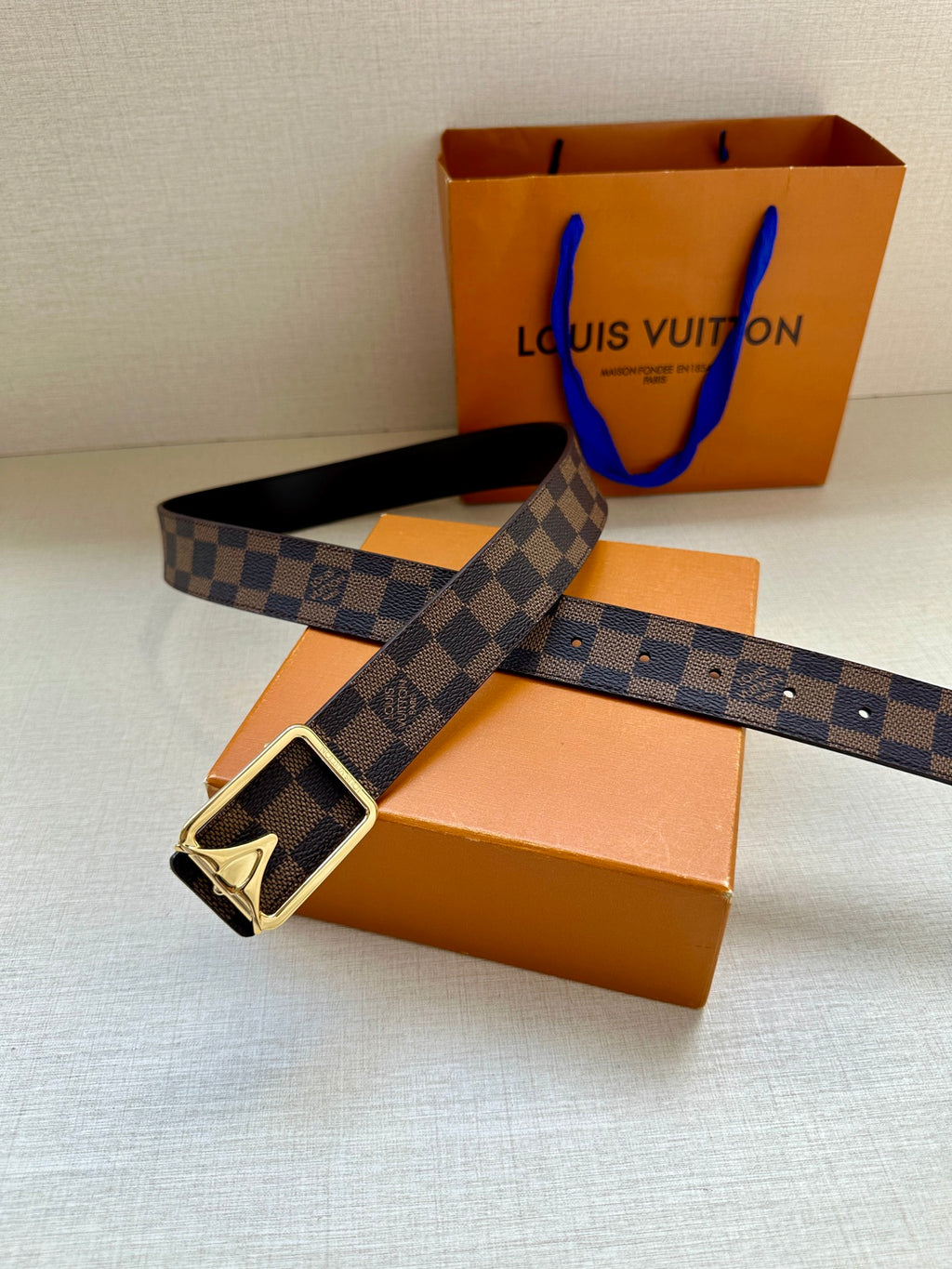 Damier check belt with dark leather strap and silver-toned buckle detail
