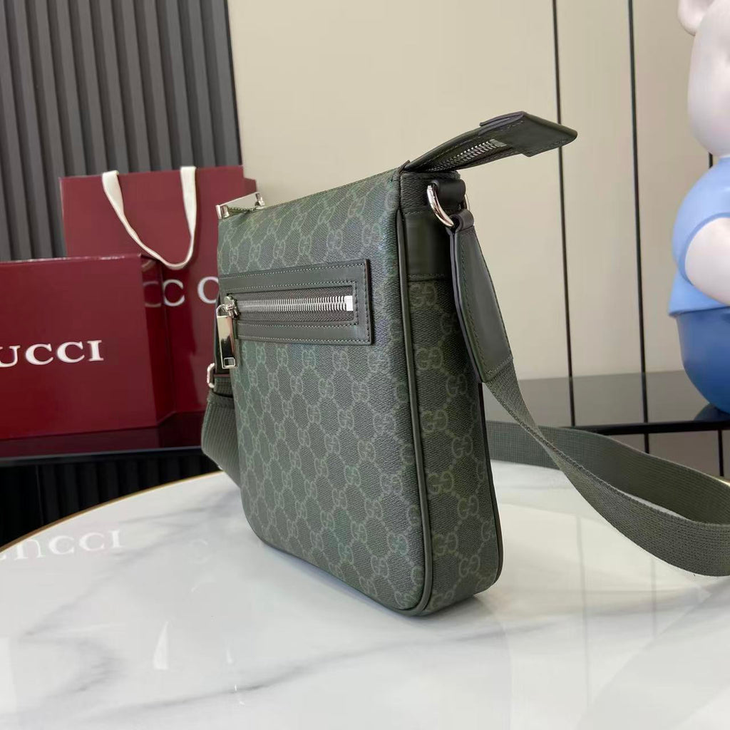 Crossbody bag three-quarter view with green GG-style monogram and wide shoulder strap