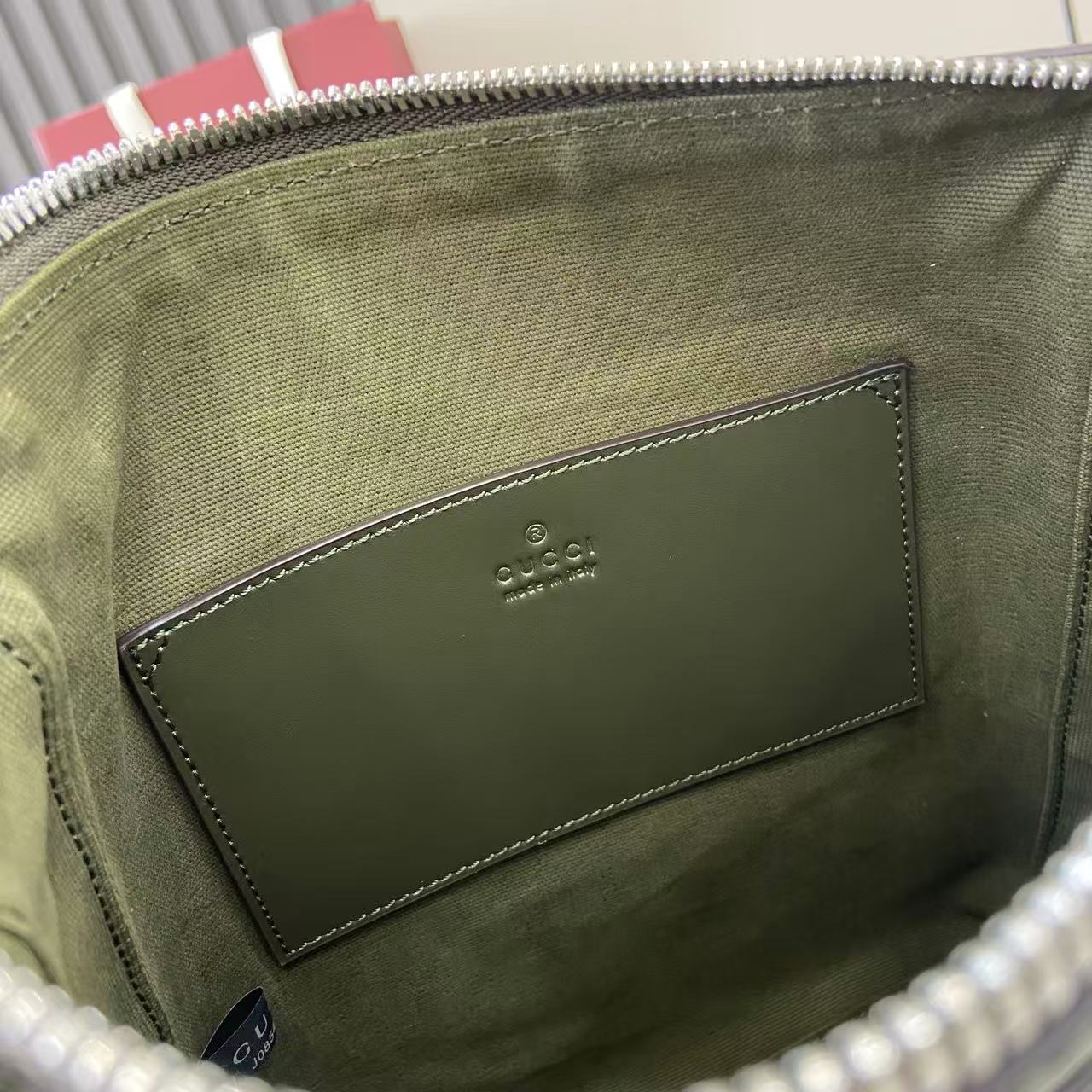 Crossbody bag interior lining with stitched leather patch and embossed logo