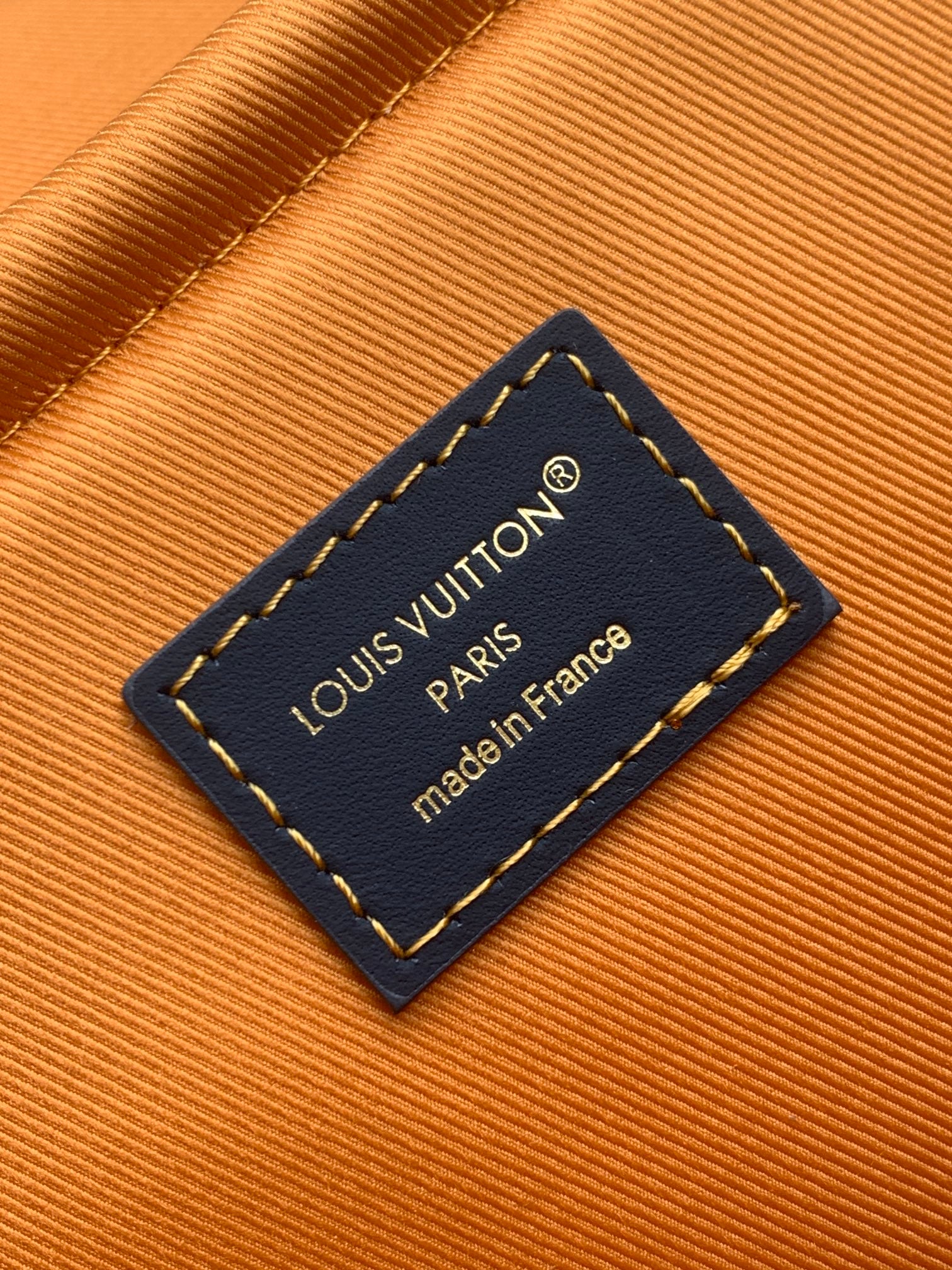 Louis Vuitton tag reading “made in France” on blue leather patch