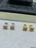 Clover stud earrings showing silver and gold tones on tray