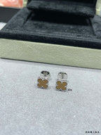 Silver-tone clover stud earrings on display tray