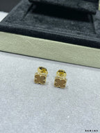 Gold-tone clover stud earrings on display tray