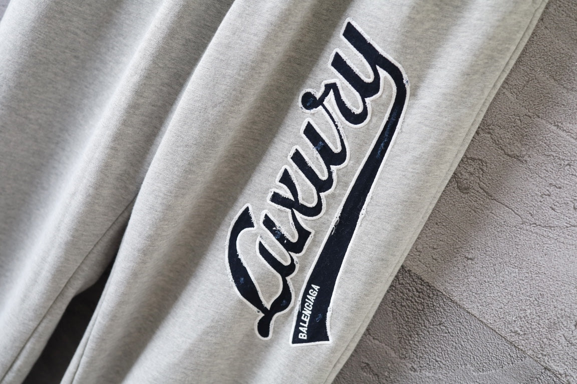 Balenciaga pants sleeve-style side graphic logo patch on light gray fabric