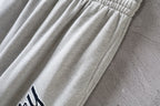 Balenciaga pants detail with gathered fabric folds on light gray leg