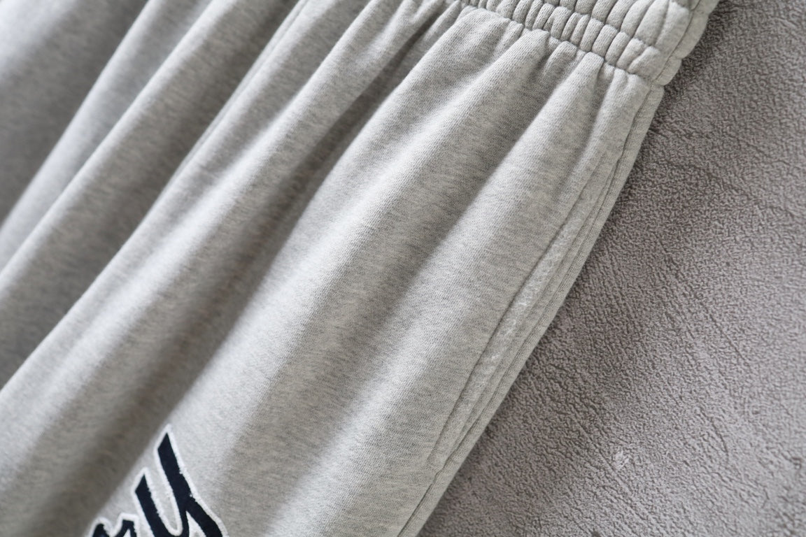 Balenciaga pants detail with gathered fabric folds on light gray leg