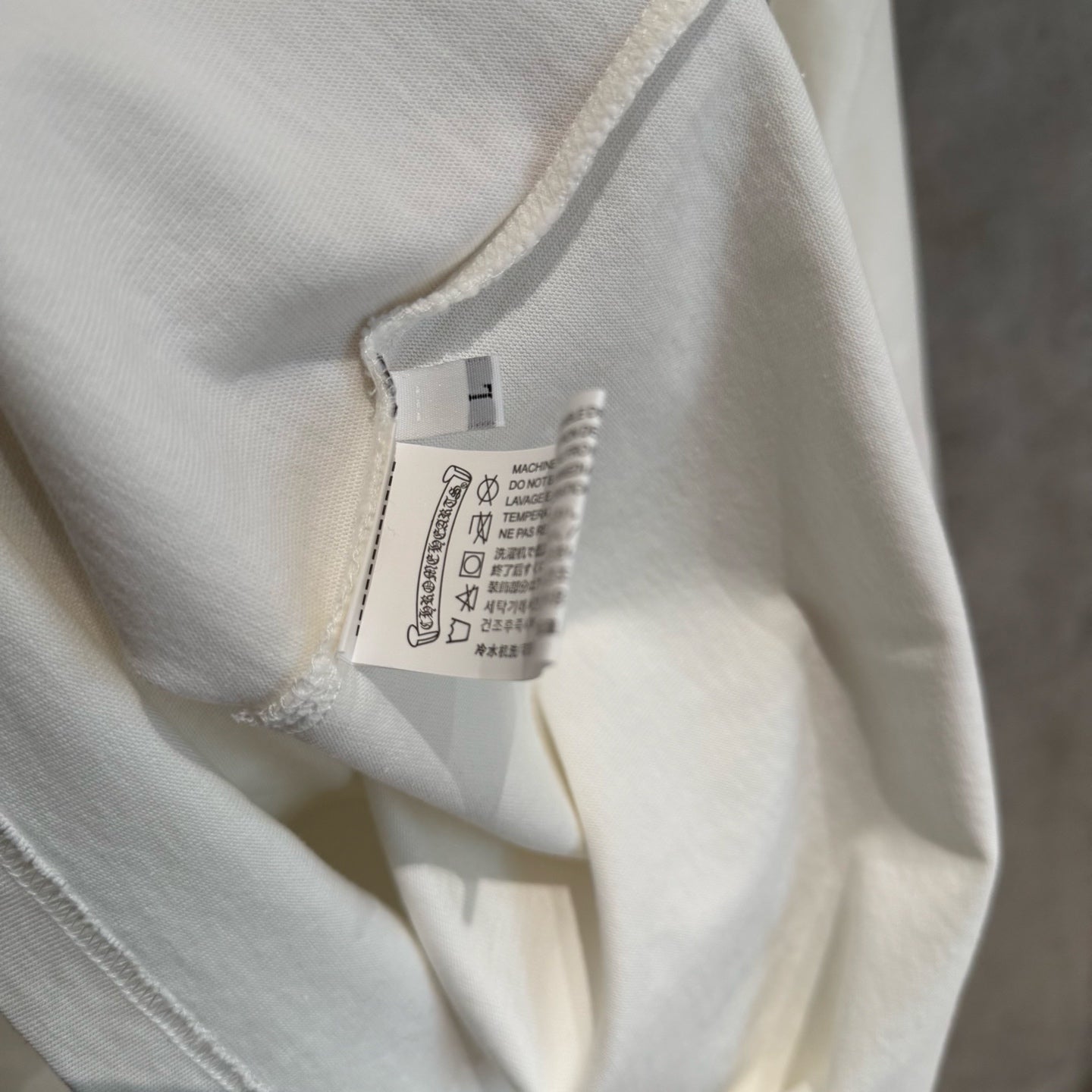 White long-sleeve T-shirt fabric and inner neck label close-up