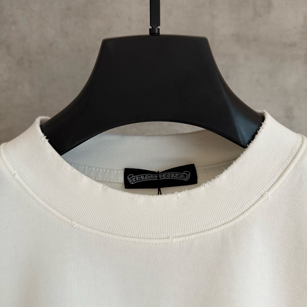 White long-sleeve T-shirt neckline close-up with black brand label inside collar