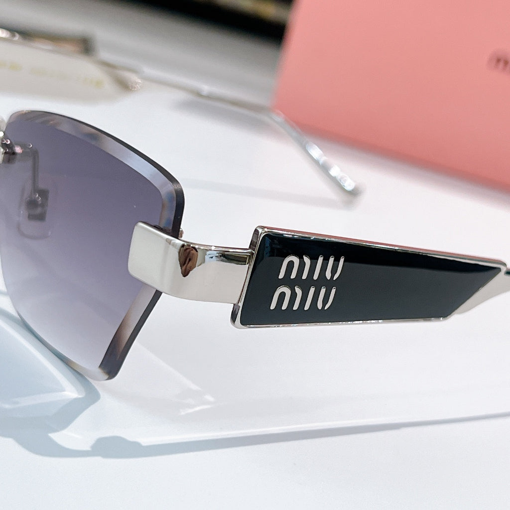 Glasses close-up: dark lenses with gold frame and miu miu logo on temple