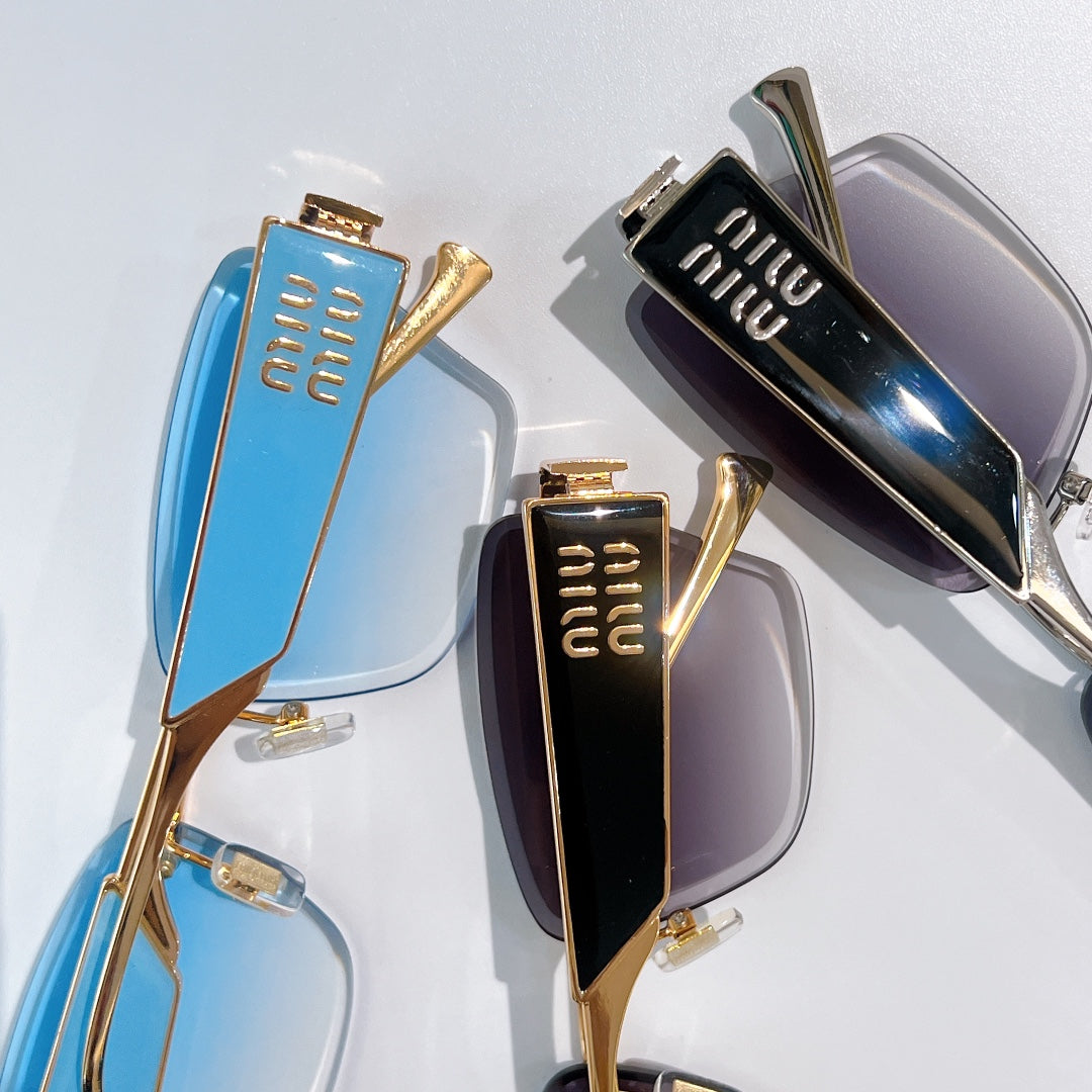 Glasses close-up: blue and black gradient lenses with gold frames and miu miu logo temples