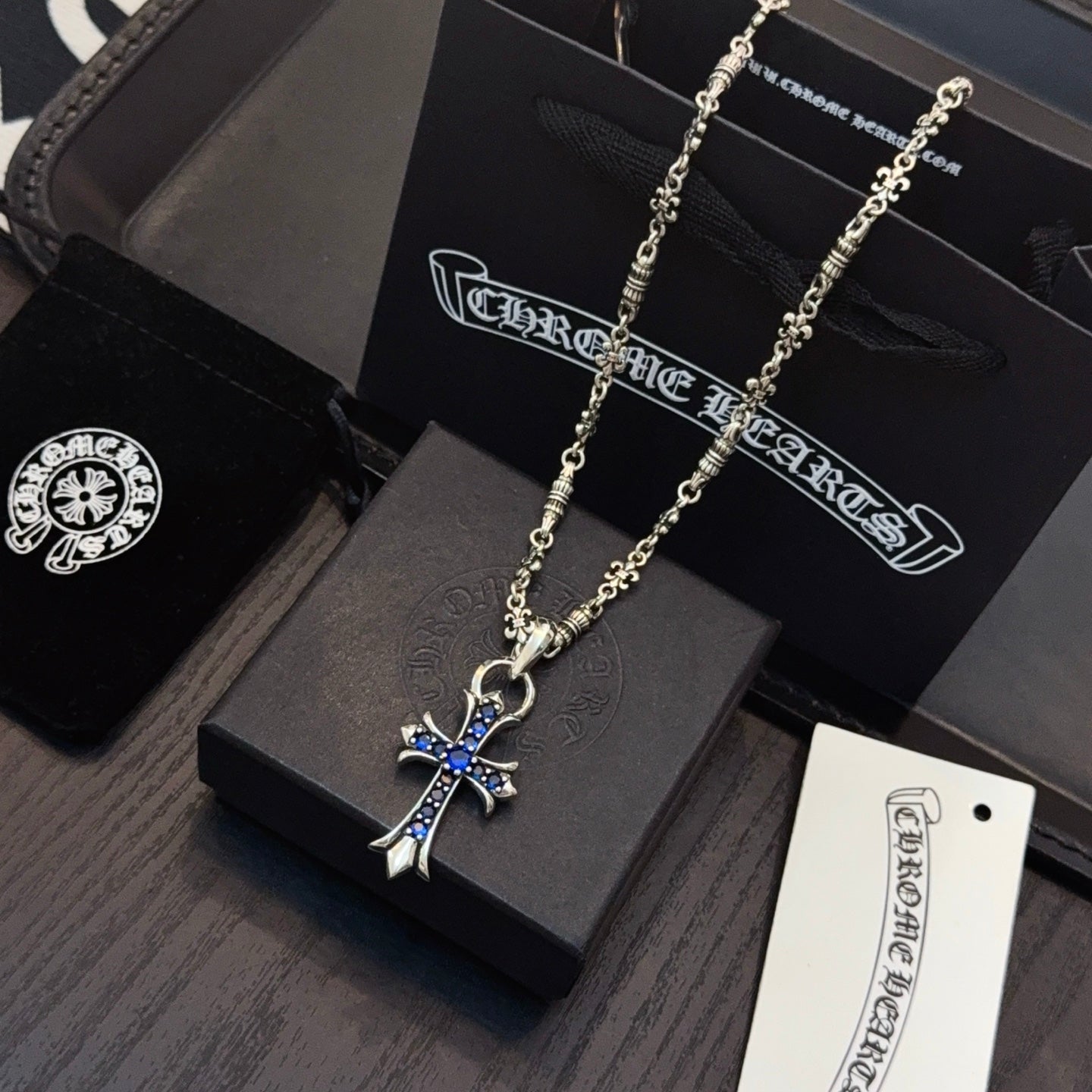 Silver cross pendant necklace with blue enamel cross charm on a chain