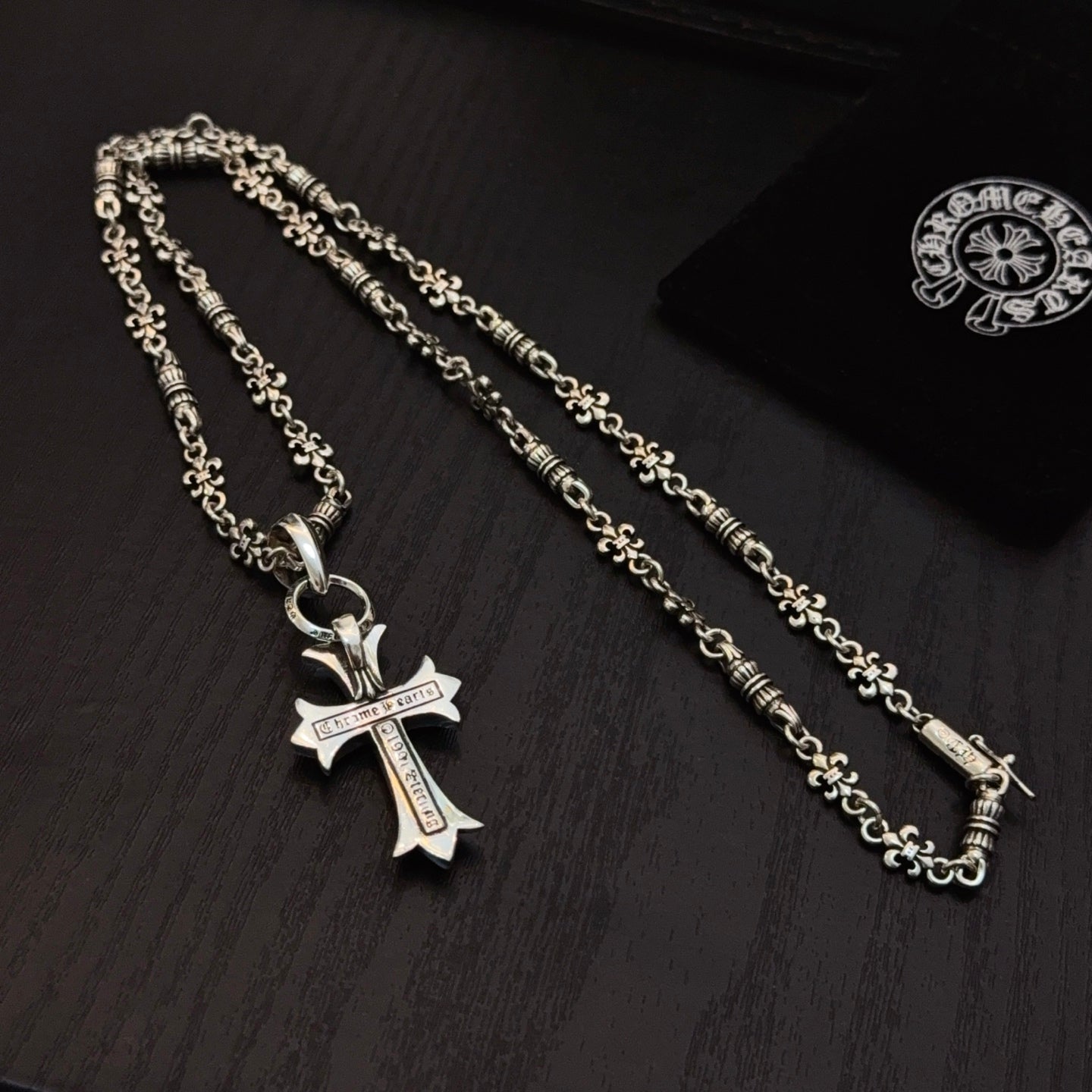 Two silver cross pendants with blue accents on linked chains