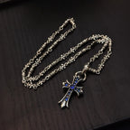 Two silver cross pendant necklaces with blue enamel charms on linked chains