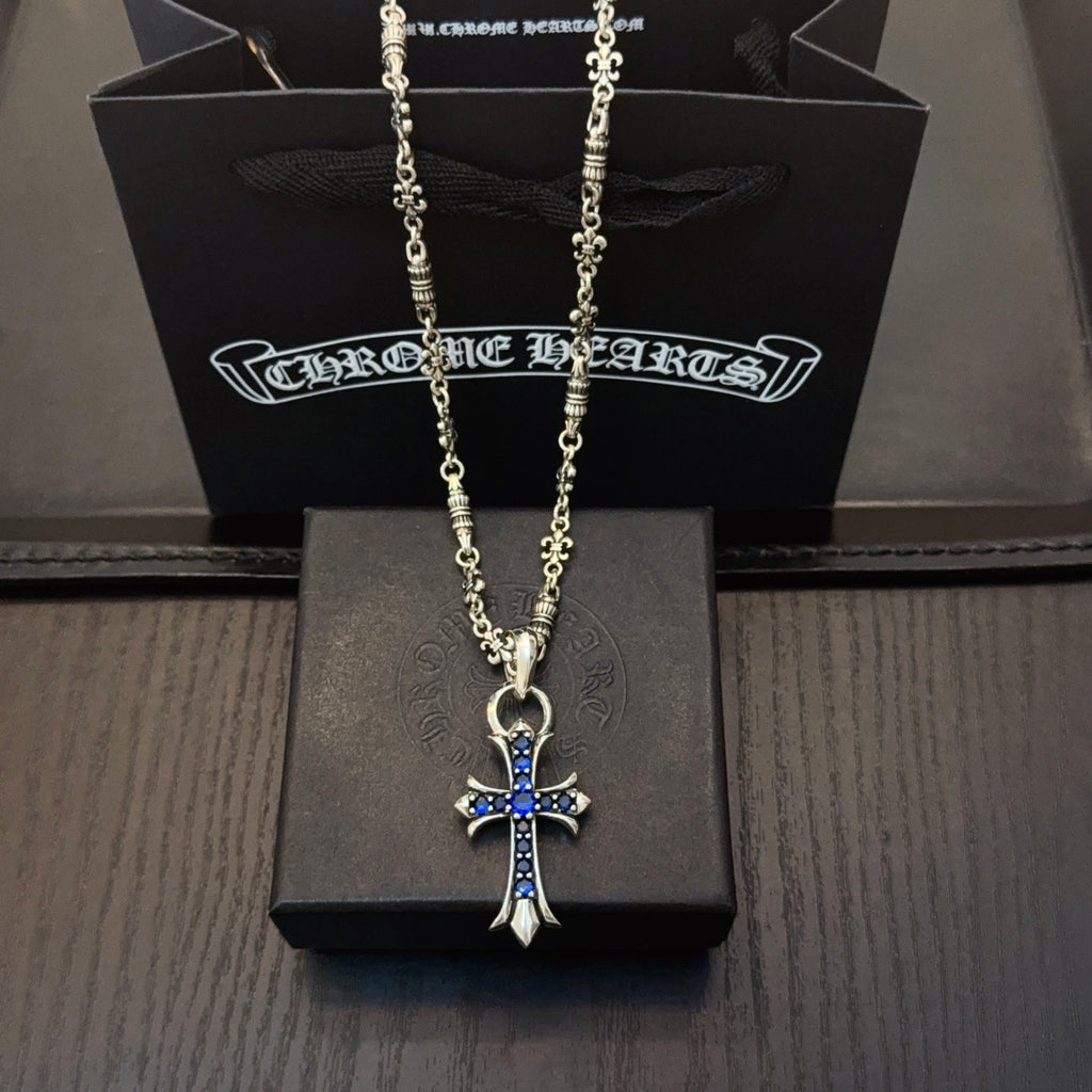 Silver cross pendant necklace with blue stone accents on a chain