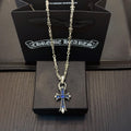 Silver cross pendant necklace with blue stone accents on a chain