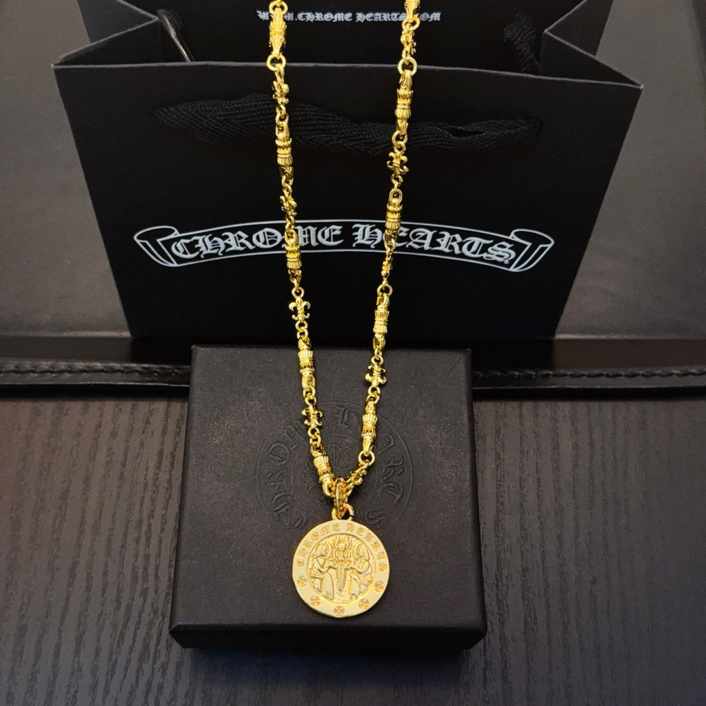 Gold-tone long necklace with round coin pendant on black jewelry box