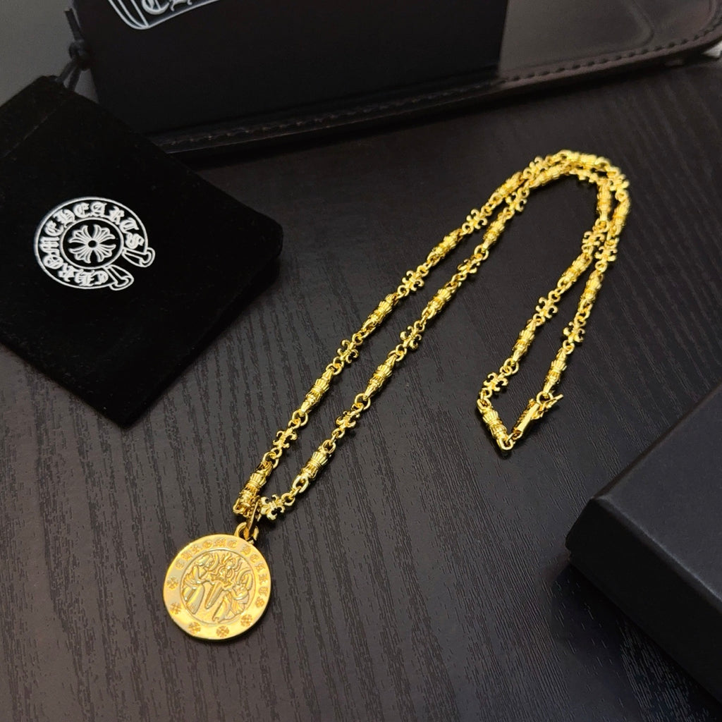 Gold-tone chain necklace with round coin pendant and matching bracelet on tray