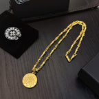 Gold-tone chain necklace with round coin pendant and matching bracelet on tray