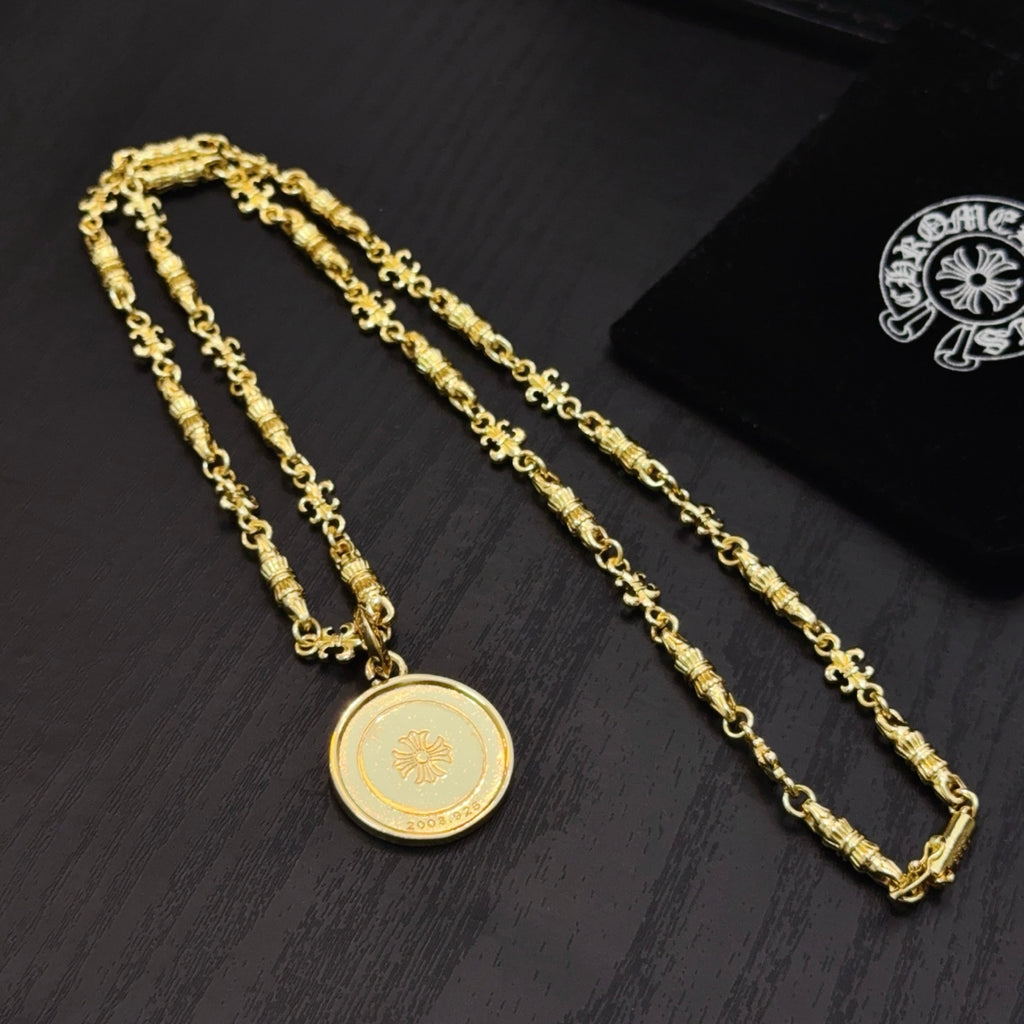 Gold-tone chain necklaces with round coin pendant on dark surface