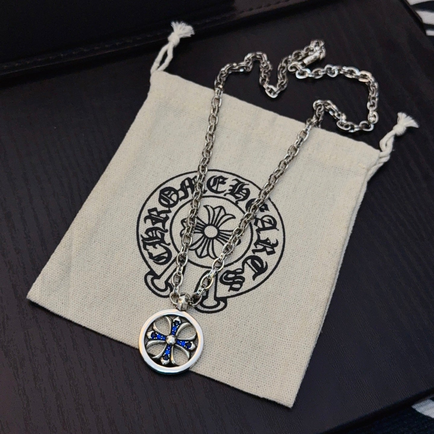 Round blue star pendant necklace with silver-tone chain in small pouch