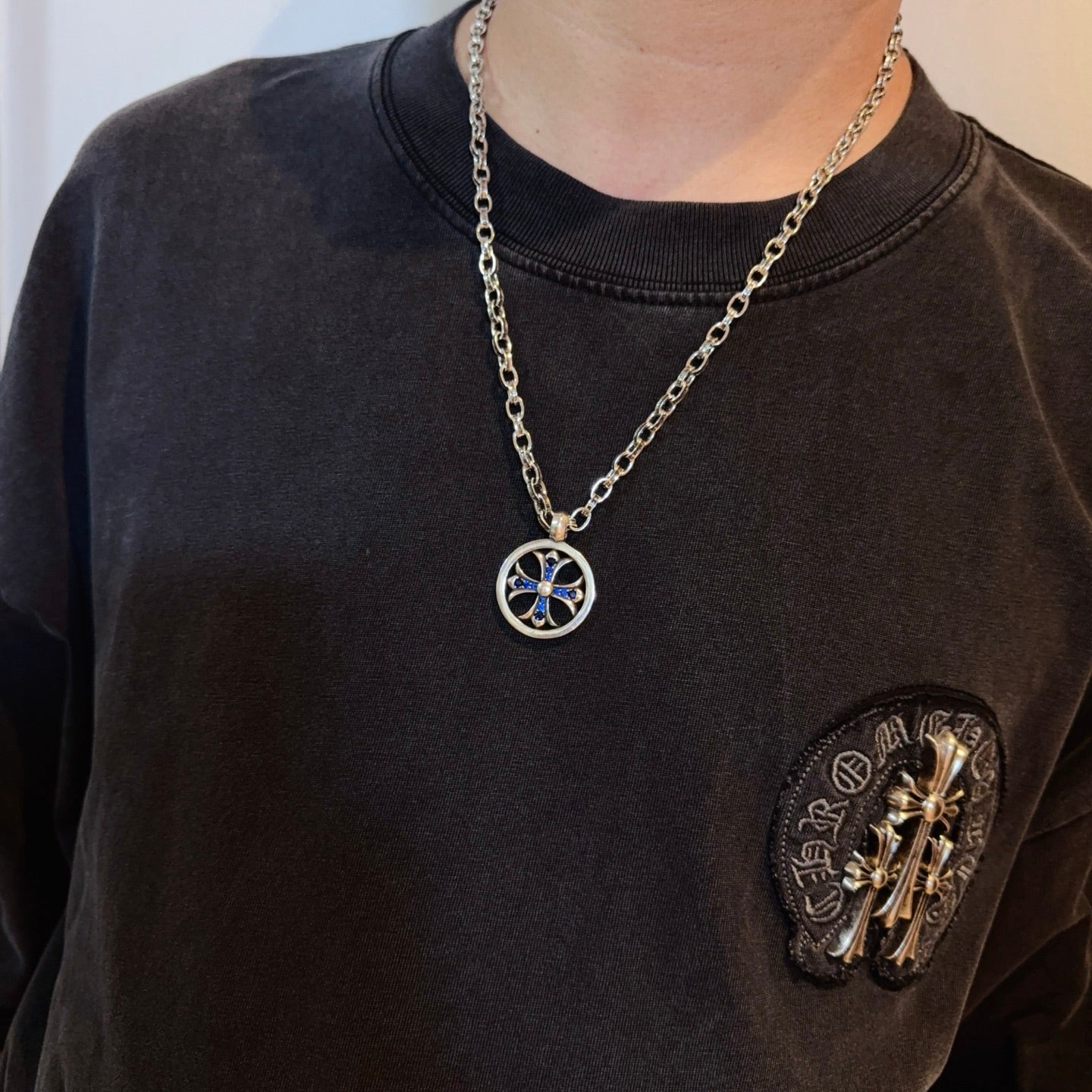 Round pendant necklace with blue star charm on silver-tone chain worn