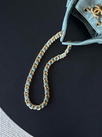 Chanel chain strap close-up on light blue bag with gold-tone links