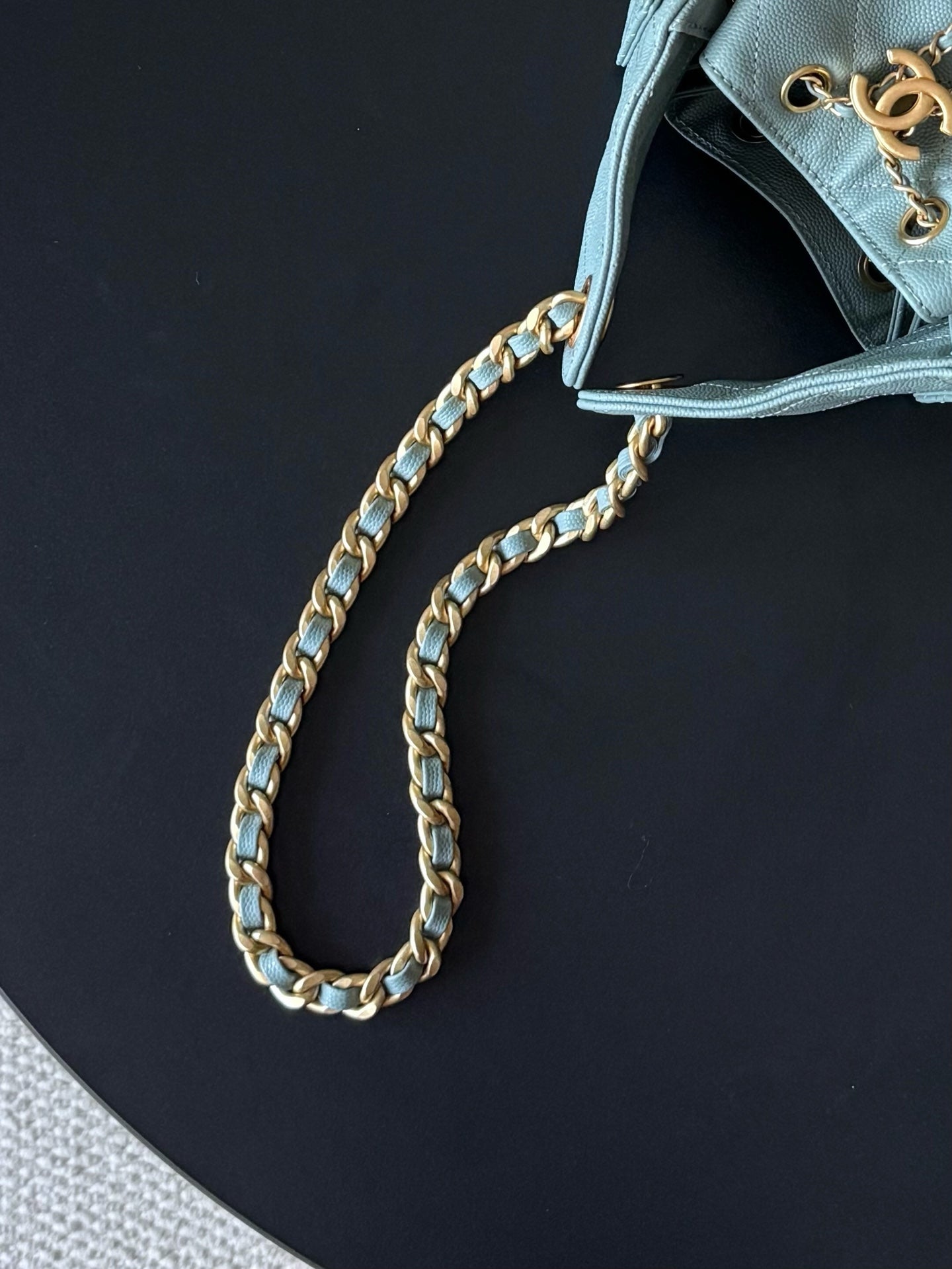 Chanel chain strap close-up on light blue bag with gold-tone links