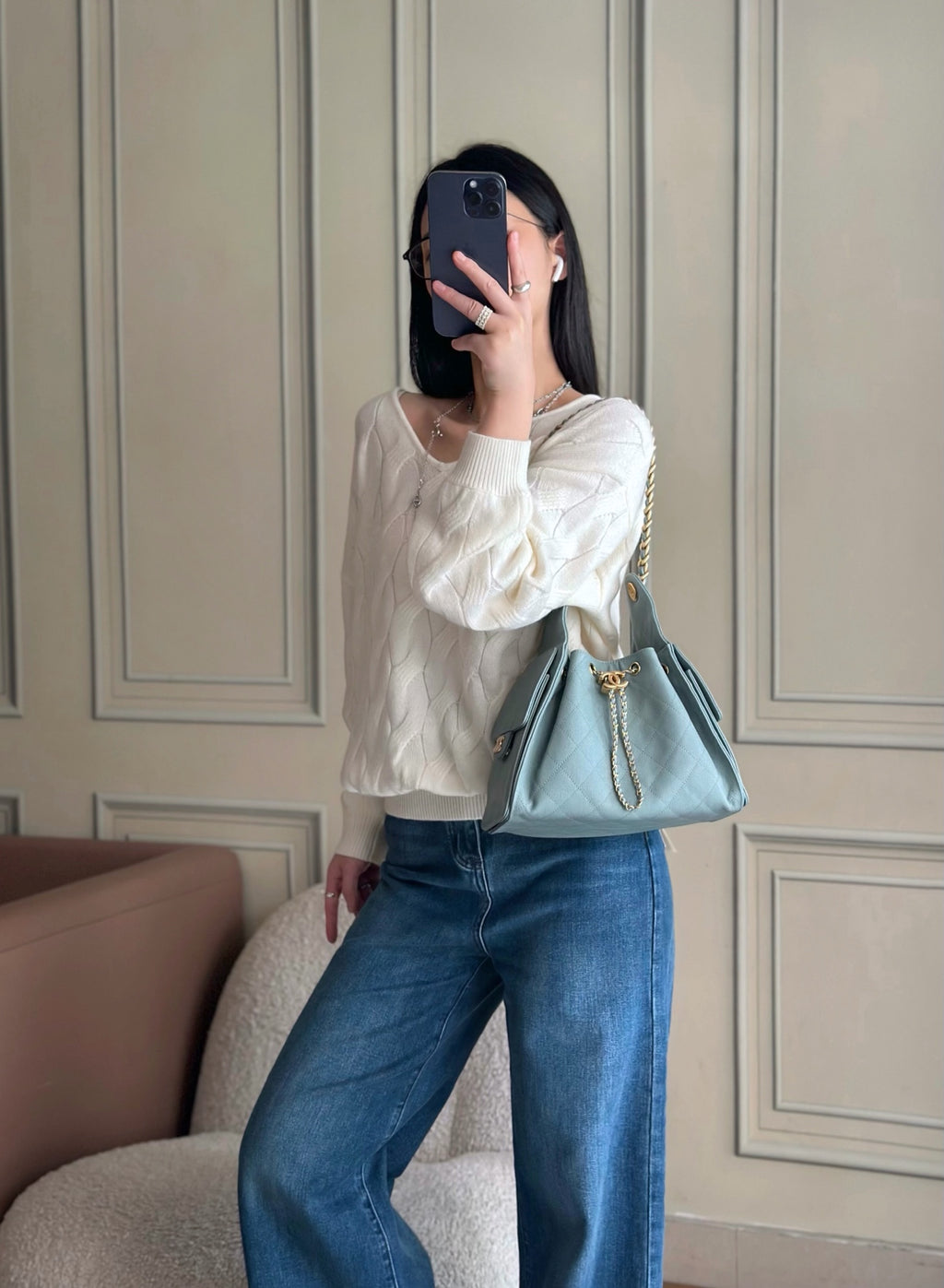 Chanel shoulder bag in light blue worn with long chain strap over jeans