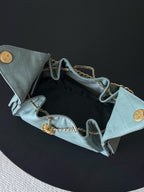 Chanel bag open interior showing light blue lining, chain straps, and gold hardware