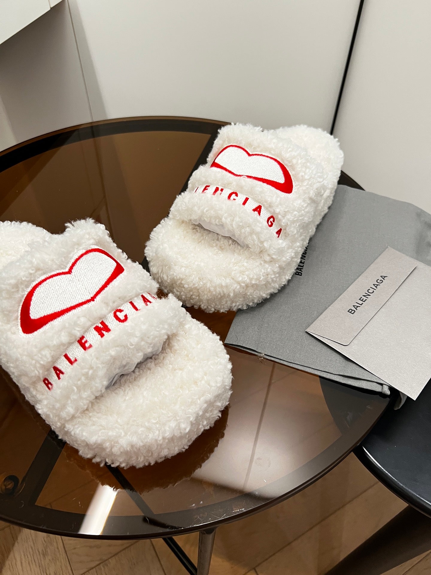 Sherpa slide sandals with red Balenciaga logo on white fuzzy straps