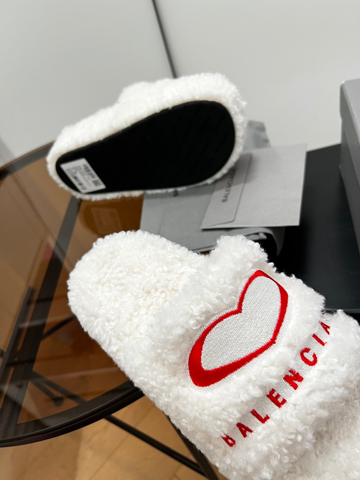 White sherpa slide sandal with red logo on strap and black insole