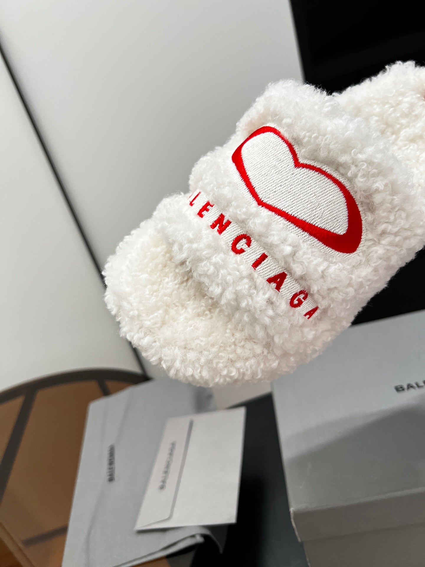 White sherpa slide sandal with red logo and BALENCIAGA text on the strap
