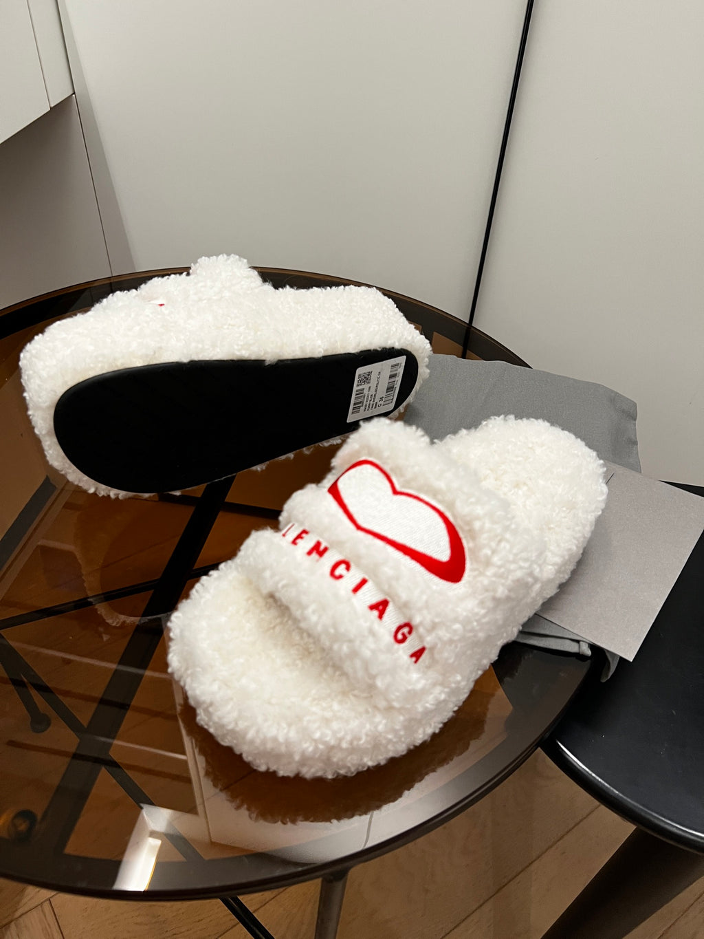 Sherpa slide sandals with red logo and black sole interior, white fuzzy straps