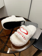Sherpa slide sandals with red logo and black sole interior, white fuzzy straps