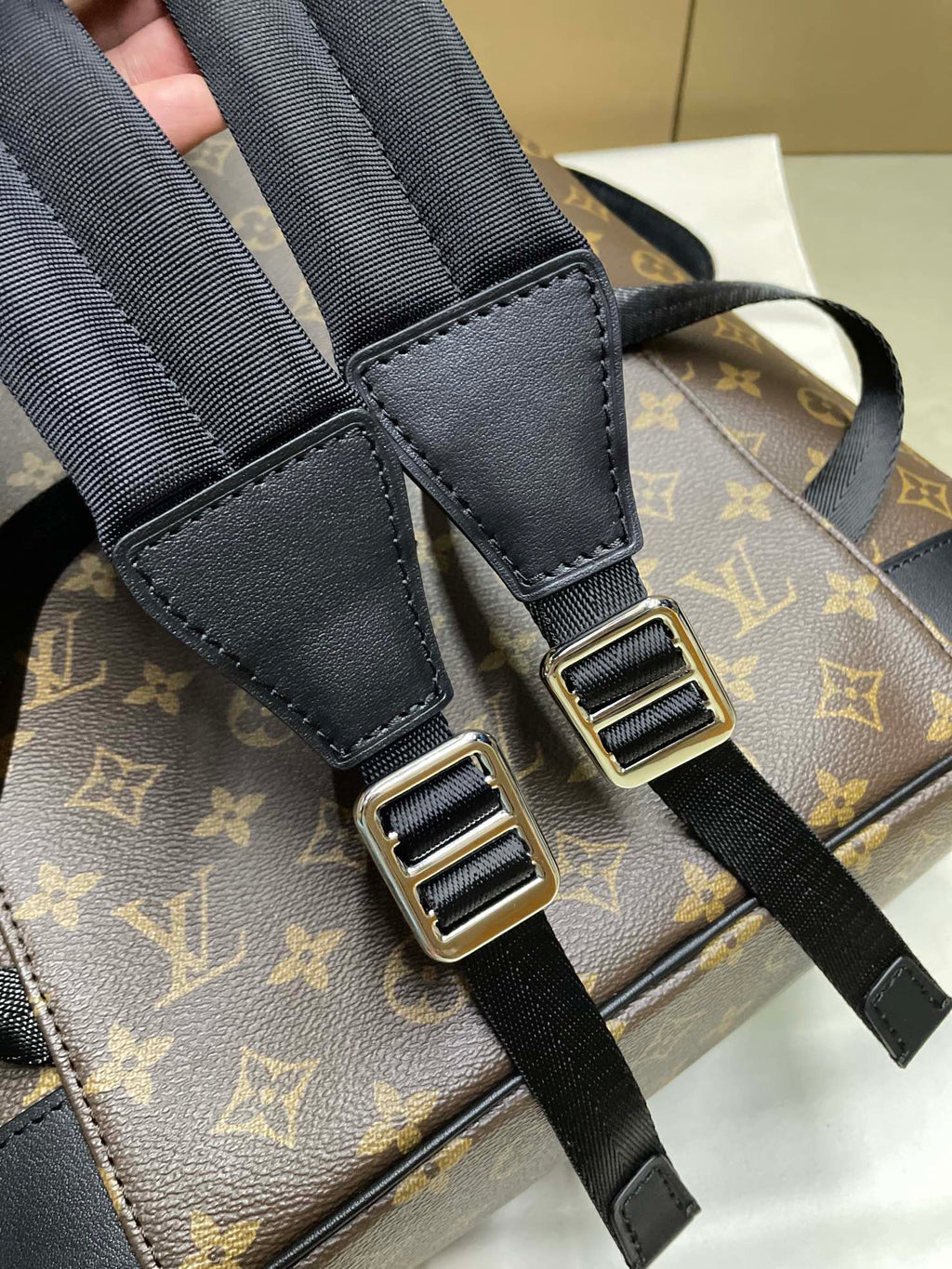 Louis Vuitton monogram backpack close-up of adjustable black strap with metal buckles